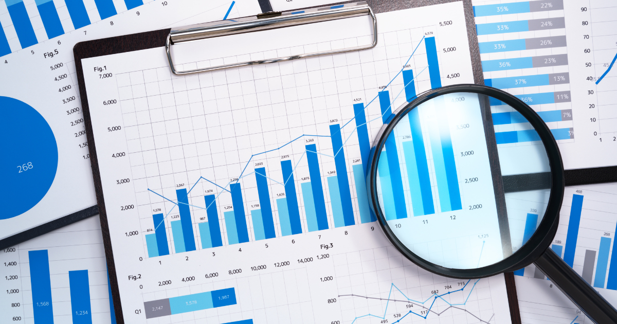 Charts and graphs on a clipboard with a magnifying glass, representing cannabis industry data and cannabis business insights for business growth provided by CannaSpyglass.