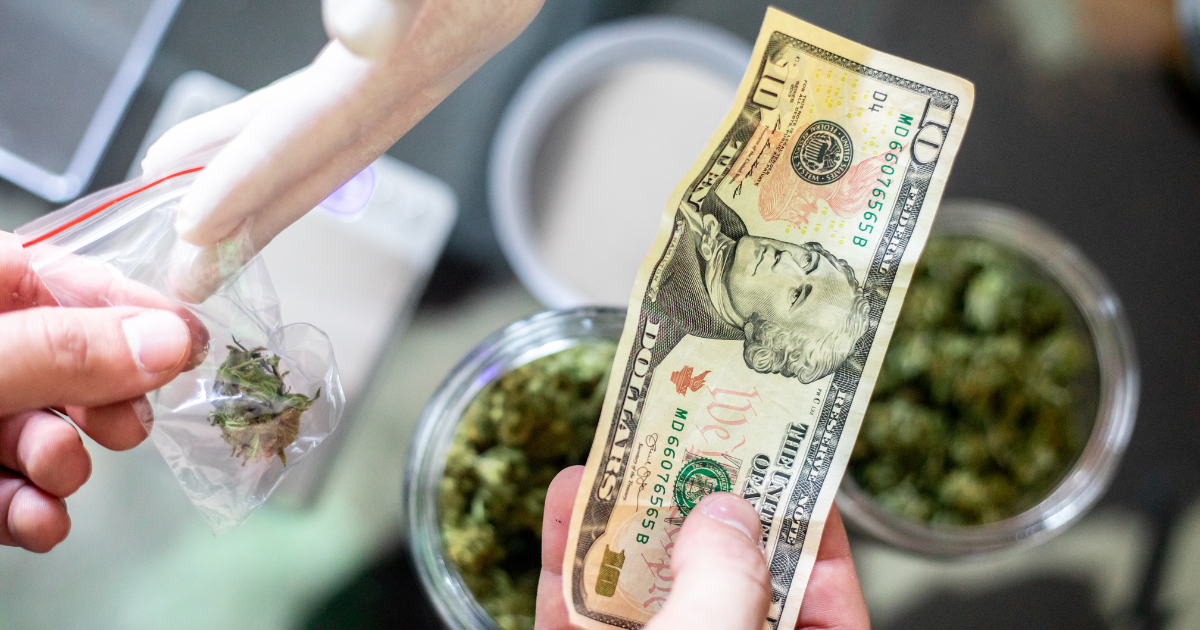 A person exchanging a ten-dollar bill for a small bag of cannabis, representing financial transactions in the cannabis industry.