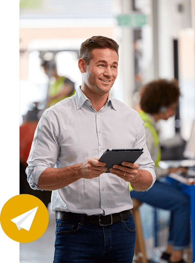A man smiling and standing in a modern office environment while holding a tablet. He reviews cannabis marking data to customize email marketing campaigns. A man smiling and standing in a modern office environment while holding a tablet. He reviews cannabis marking data to customize email marketing campaigns.